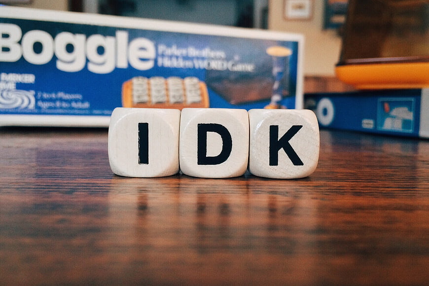 IDK Acronym on Wooden Letter Cubes with Board Game Background
