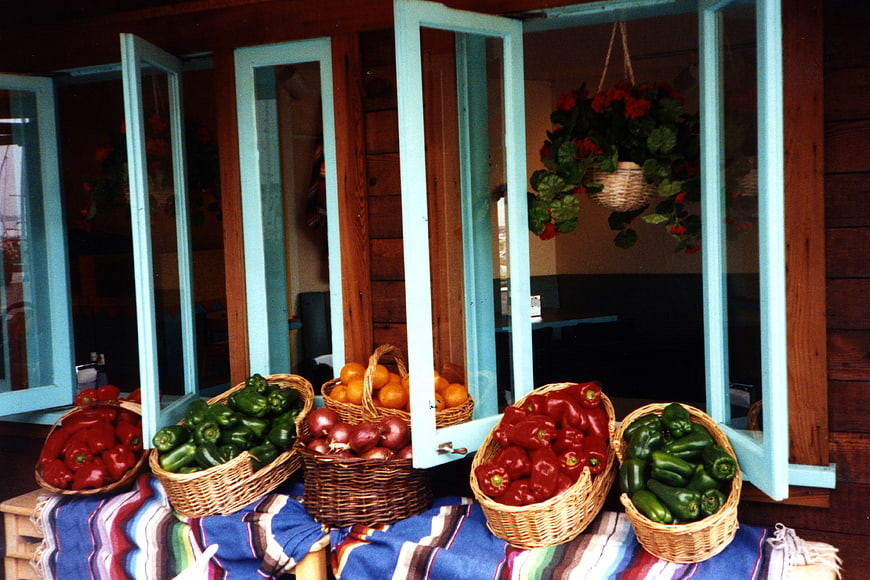Fresh vegetables in wicker baskets on a colorful tablecloth
