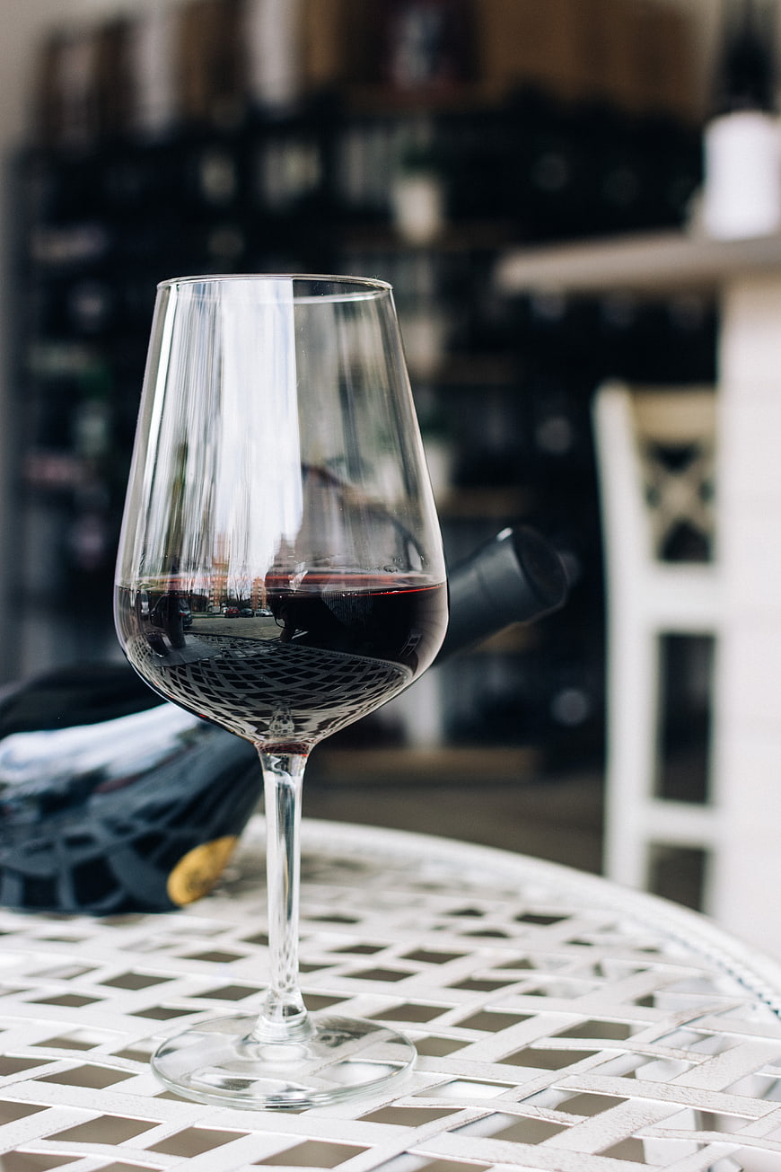 Glass of red wine on white metal table