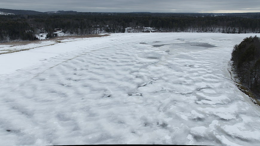 Aerial view of frozen lake with snow and ice texture