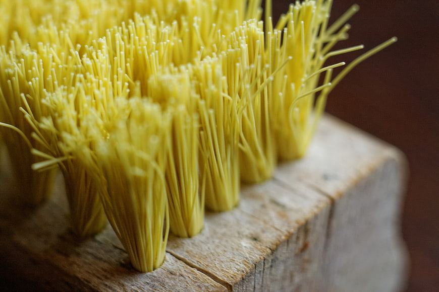 Close-up of yellow bristles on a wooden brush handle
