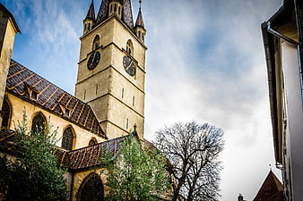 Historic church tower with clock against blue sky