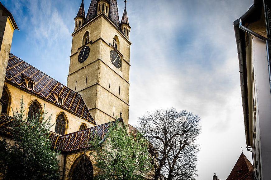 Historic church tower with clock against blue sky