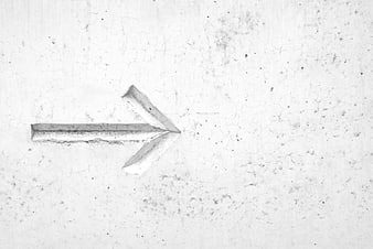 Hand-painted white arrow on textured concrete wall