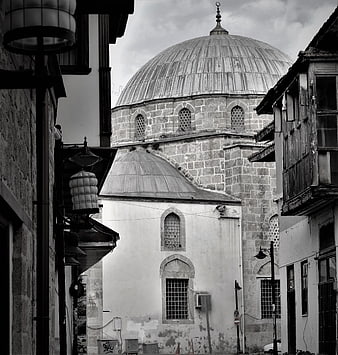 Black and white view of historic mosque dome in narrow street