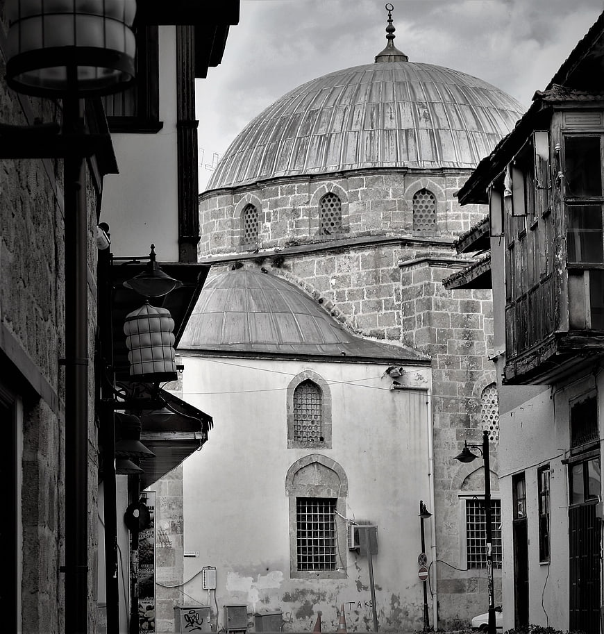 Black and white view of historic mosque dome in narrow street
