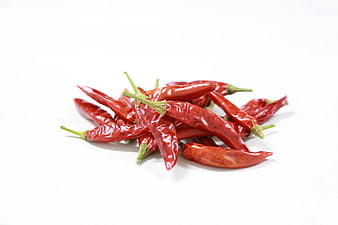 Pile of dried red chili peppers on white background
