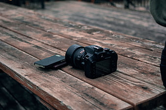DSLR Camera and Smartphone on Rustic Wooden Table