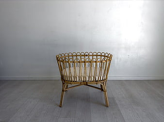 Minimalist rattan baby crib in bright white room
