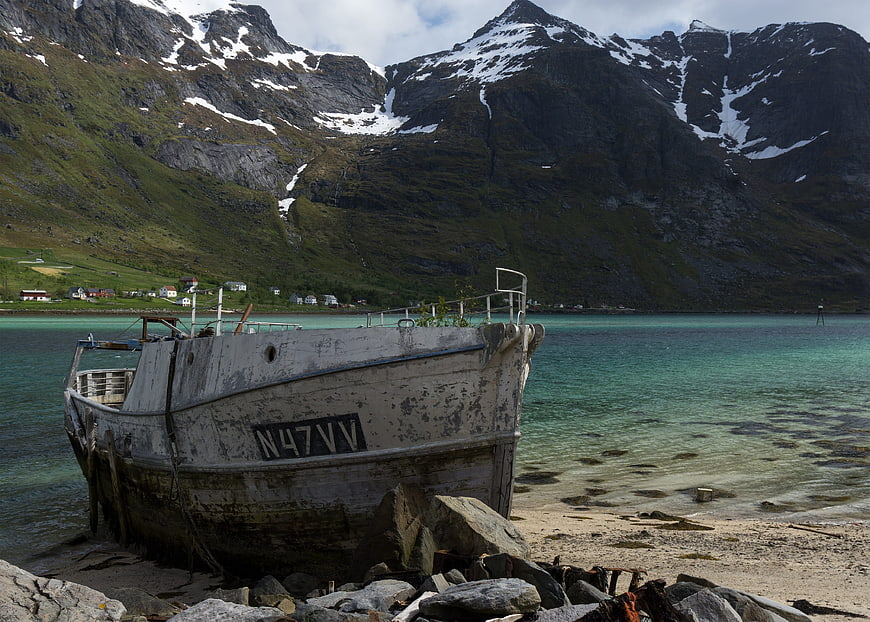 Old weathered fishing boat on a sandy beach in a Norwegian fjord