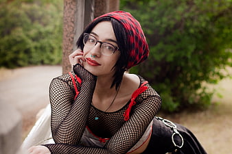 Portrait of woman with red headscarf and fishnet top outdoors