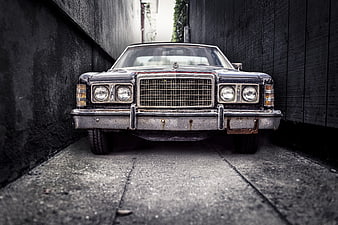 Front view of vintage black Ford car in narrow alley