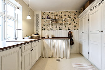 Bright White Kitchen Interior With Floral Wallpaper And Wooden Countertops
