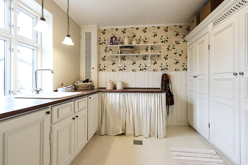 Bright White Kitchen Interior With Floral Wallpaper And Wooden Countertops