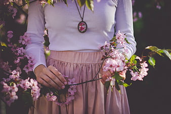 Woman holding cherry blossom branch in spring garden