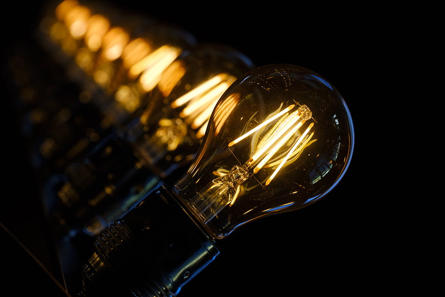 Illuminated Edison Bulb Row on Black Background