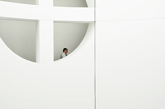Minimalist white architecture with man in circular window