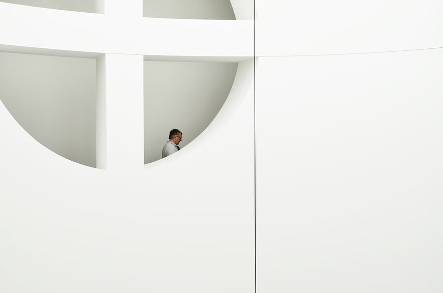 Minimalist white architecture with man in circular window