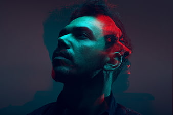 Double exposure portrait of man with red and blue neon lighting