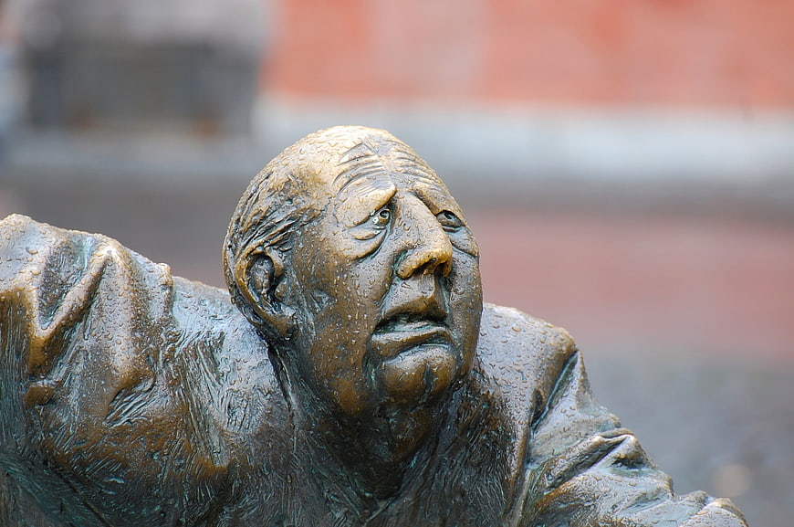 Close-up of bronze sculpture face with water droplets