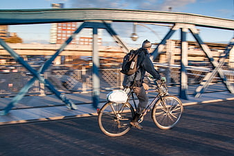 Cyclist riding bike across urban bridge with motion blur