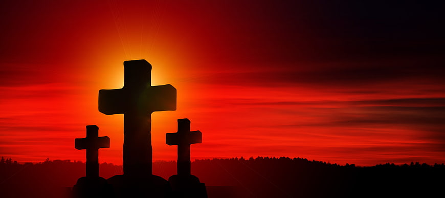 Silhouette of Three Crosses Against Dramatic Red Sunset Sky