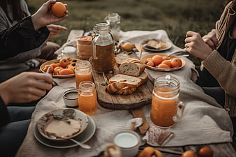 Outdoor picnic breakfast with bread, juice, and fruit
