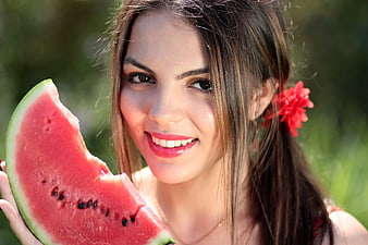 Happy woman eating watermelon slice outdoors in summer