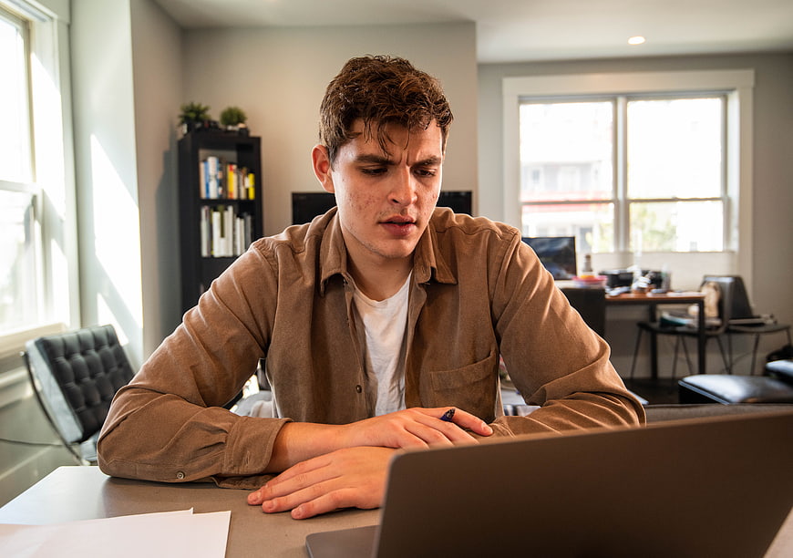 Young man working on laptop in home office