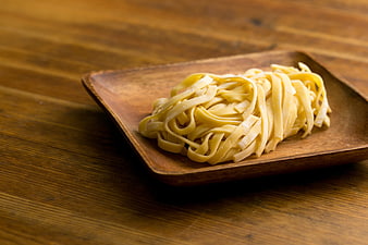 Uncooked Fettuccine Pasta on Wooden Plate