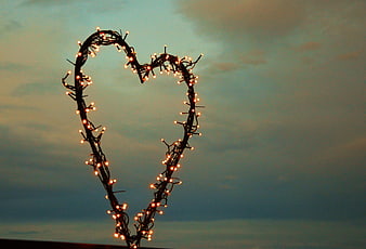 Heart-shaped fairy lights against a twilight sky