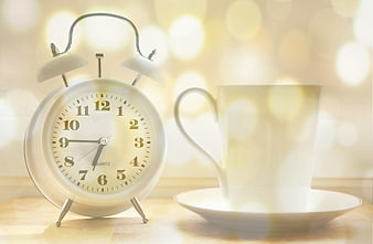 Vintage Alarm Clock and White Coffee Cup on Wooden Table