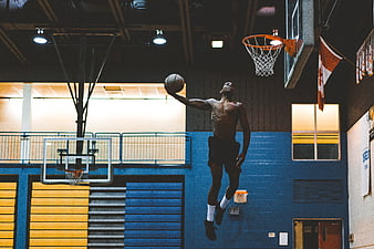 Athletic Man Dunking Basketball in Indoor Gym