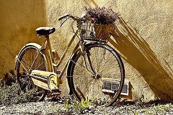 Vintage Yellow Bicycle with Basket Against Textured Wall