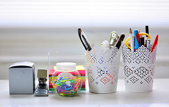 White Office Desk Supplies With Pens, Paperclips, And Stapler