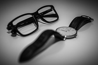 Black and white glasses and watch on white background