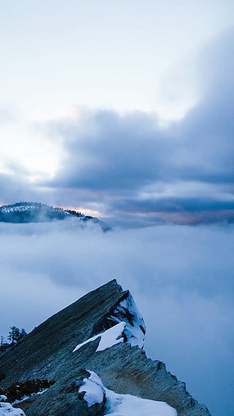 Snowy Mountain Peak Above Sea of Clouds