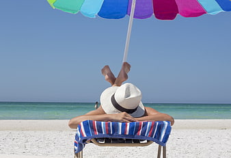 Relaxing on Beach Chair Under Colorful Umbrella