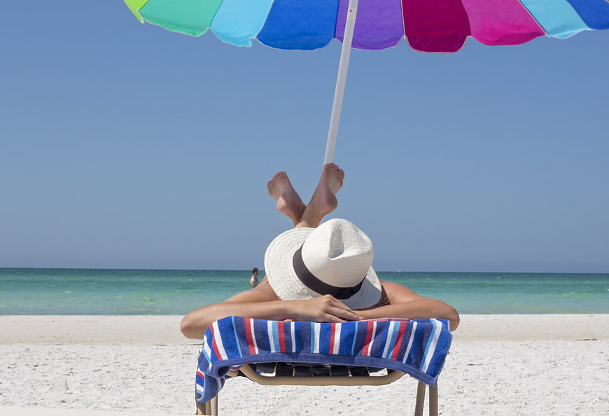 Relaxing on Beach Chair Under Colorful Umbrella