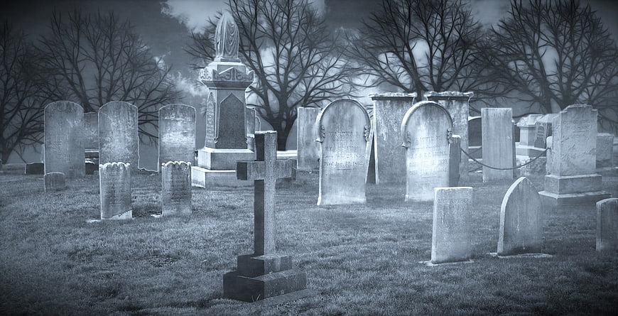 Spooky Old Graveyard with Tombstones and Bare Trees
