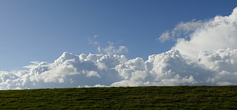 Dramatic Cumulus Clouds Over Green Rolling Hill