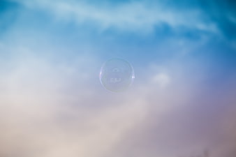 Soap Bubble Floating Against Soft Blue and Purple Sky