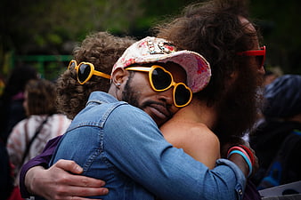 Two Men Hugging at Pride Festival with Heart Sunglasses