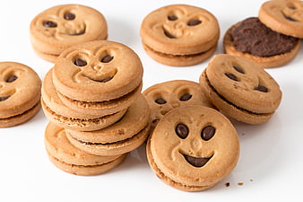 Smiling chocolate chip sandwich cookies on white background