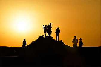 Silhouette of Group of People on Hill at Sunset