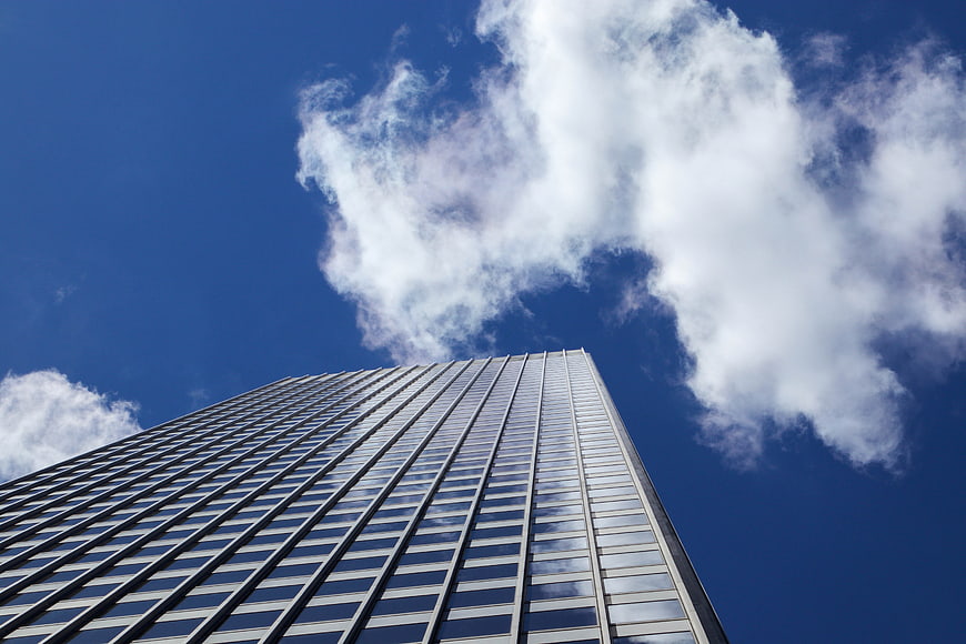 Low angle view of modern skyscraper against blue sky
