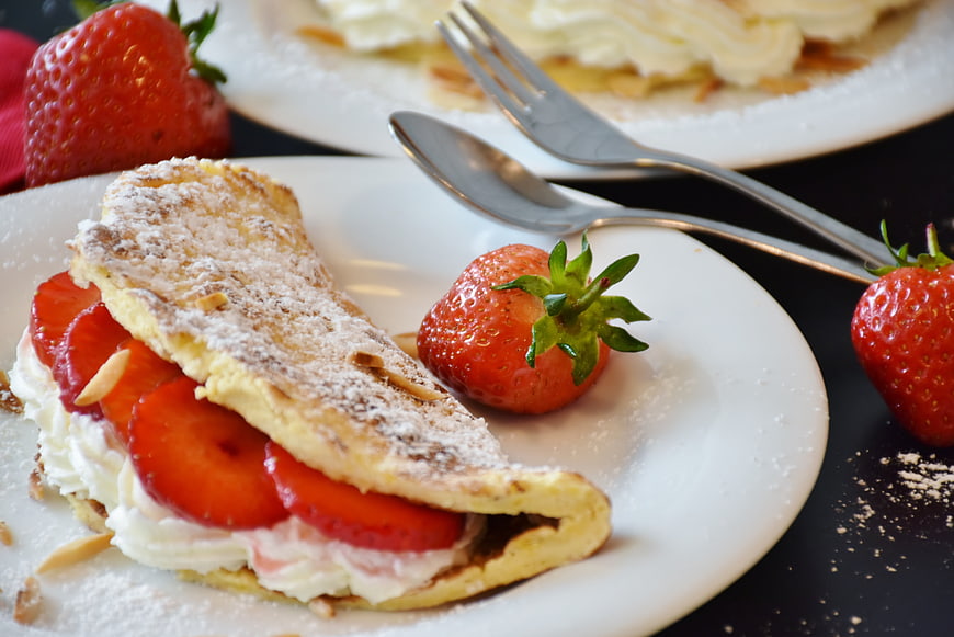 Strawberry crepe dessert with cream and powdered sugar