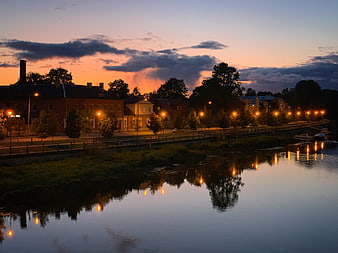 Serene River Sunset with City Reflections and Streetlights