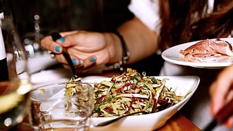 Woman Eating Endive Salad with Prosciutto at Restaurant