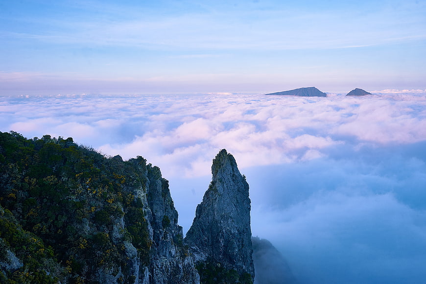 Dramatic mountain peaks rising above a sea of clouds at sunrise